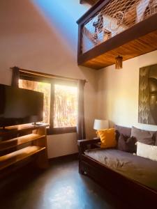 a bedroom with a bed and a tv and a window at Lua Villas in Santa Teresa Beach