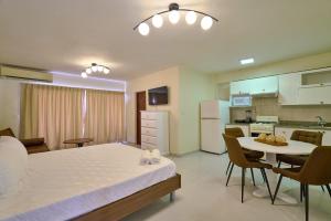 a room with a bed and a table and a kitchen at Roy Arias Suites & Residences in Santo Domingo