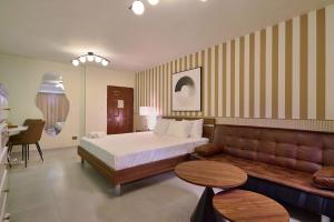 a hotel room with a bed and a couch at Roy Arias Suites & Residences in Santo Domingo +47 photos