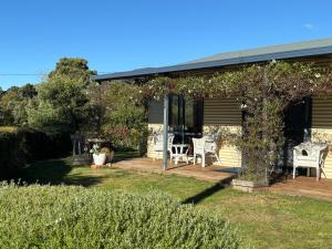 a house with a porch with a table and chairs at Bruny Serenade in Adventure Bay
