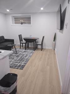 a living room with a table and chairs at Cozy 1-Bedroom Private Basement Suite in Winnipeg with separate entrance in Winnipeg +10 photos
