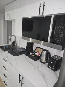 a kitchen counter with a microwave and appliances on it at Cozy 1-Bedroom Private Basement Suite in Winnipeg with separate entrance in Winnipeg