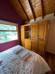 a bedroom with a large bed and a window at Aromas de Montaña III in Junín de los Andes