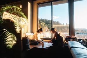 two women sitting on the floor looking out of a window at RoheN ASHINOKO in Hakone