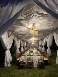 a white tent with a long table with chairs at Domaine Ghait in Had Abdallah Rhiat +76 photos