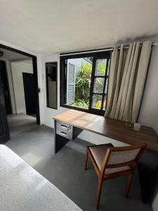 a bedroom with a desk and a window with a chair at Hostel El viajero in Tramandaí +15 photos
