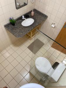 a bathroom with a toilet and a sink at Family Beach flat - frente ao mar in Barra de São Miguel