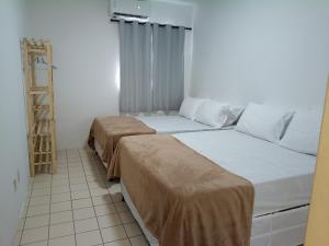 two beds in a small room with a ladder at Family Beach flat - frente ao mar in Barra de São Miguel