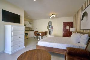 a bedroom with a large bed and a table at Roy Arias Suites & Residences in Santo Domingo