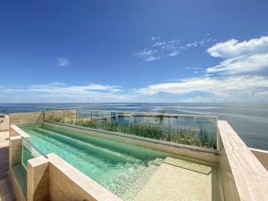 a swimming pool with a view of the ocean at Distrito Puerto by Andiani Travel in Puerto Morelos