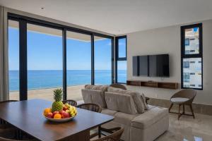 a living room with a table with a bowl of fruit on it at Distrito Puerto by Andiani Travel in Puerto Morelos