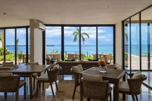 a restaurant with tables and chairs and a view of the ocean at Distrito Puerto by Andiani Travel in Puerto Morelos