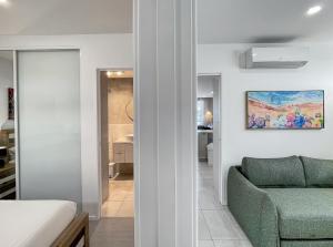 a living room with a green chair and a couch at Bay View 2-Bedroom Apartment in Batemans Bay +26 photos