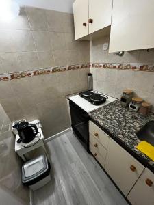 a small kitchen with a stove and a counter top at Departamento Del Plaza in Bahía Blanca