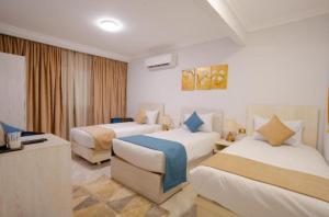 a hotel room with two beds and a television at pyramids View Top in Cairo +5 photos
