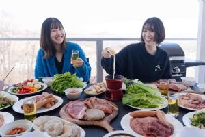 two women sitting at a table full of food at 白樺湖Lake View in Chino