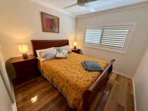 a bedroom with a bed and two night stands and a window at Coolamon in Ballina
