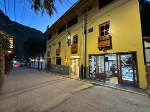 an empty street in front of a yellow building at Andher Palaces Hotel in Ollantaytambo
