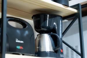 a black coffee maker sitting on a shelf at Studio confort com ar Centro de Niteroi in Niterói
