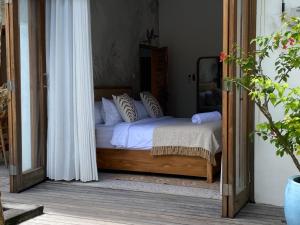 a bedroom with a bed with white sheets and pillows at Villa Alam in Nusa Lembongan +18 photos