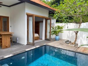 a villa with a swimming pool and a bedroom at Villa Alam in Nusa Lembongan