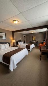 a hotel room with two beds and a desk at Beaver Motel in Wawa