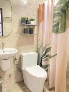 a bathroom with a toilet and a sink at Bahay-Kapehan sa Villa in Tambo +41 photos