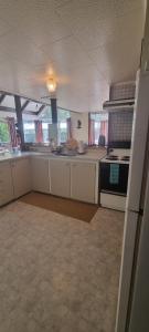 a kitchen with white cabinets and a stove at Waypoint Lodge in Naseby