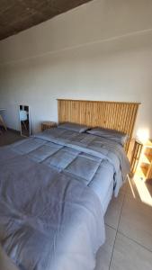 a large bed with a wooden headboard in a bedroom at Apart Z Alberdi in Belén de Escobar