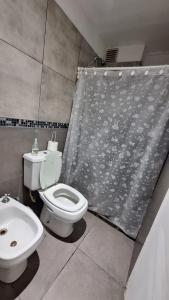 a bathroom with a toilet and a sink and a shower curtain at Apart Z Alberdi in Belén de Escobar +7 photos