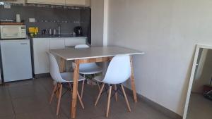 a kitchen with a table and two white chairs at Apart Z Alberdi in Belén de Escobar