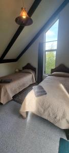 a bedroom with two beds and a window at Waypoint Lodge in Naseby