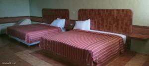 a hotel room with two beds and a chair at Campo Real Actopan in Cedro