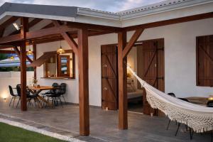 a patio with a hammock and a table and chairs at Villa Belle Ile en Mer in Capesterre