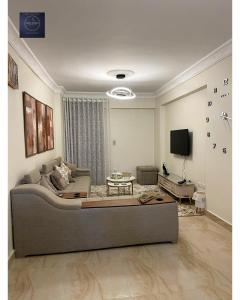 a living room with a couch and a tv at Half Moon Apartaments in Alexandria
