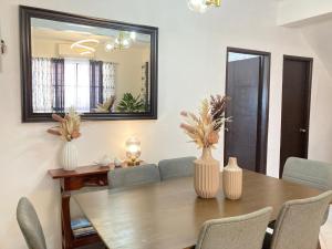 a dining room with a table with chairs and a mirror at Bahay-Kapehan sa Villa in Tambo
