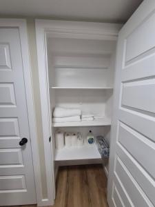 a closet with white towels and a door at Clear Edge Suites in Saskatoon
