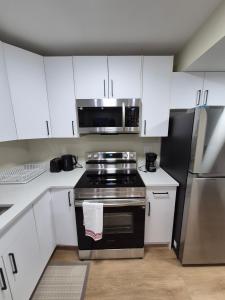 a kitchen with a stove and a microwave at Clear Edge Suites in Saskatoon