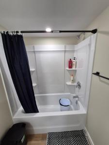a bathroom with a bath tub with a shower curtain at Clear Edge Suites in Saskatoon +15 photos