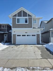 a large house with a white garage door at Clear Edge Suites in Saskatoon