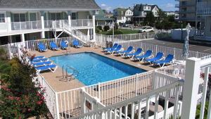 a swimming pool with blue lounge chairs and a swimming poolvisor at Condo At The Cove Unit 5 in Cape May