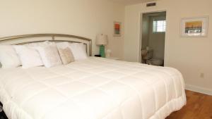 a white bed with white pillows in a bedroom at Condo At The Cove Unit 5 in Cape May