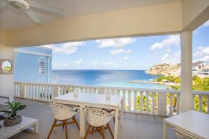 a balcony with a table and chairs and the ocean at Spacious Ocean View Apartments with Balcony in Blue Bay in Blue Bay