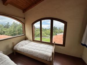 a room with two windows and a bed in it at Casa Tafi del Valle in Tafí del Valle