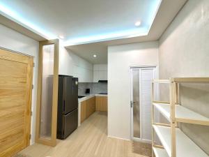 a large kitchen with a refrigerator and a counter at Dasma stay - Private Jacuzzi and Skyline Views in Dasmariñas