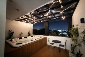 a bath room with a tub and a table and chairs at Dasma stay - Private Jacuzzi and Skyline Views in Dasmariñas