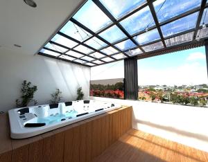 a bathroom with a bath tub and a large window at Dasma stay - Private Jacuzzi and Skyline Views in Dasmariñas