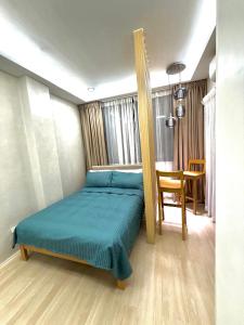 a bedroom with a bed and a table in it at Dasma stay - Private Jacuzzi and Skyline Views in Dasmariñas