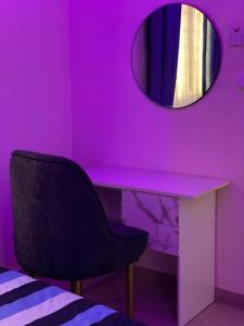 a pink room with a chair and a mirror at Luxury and premium one bed in Ikeja