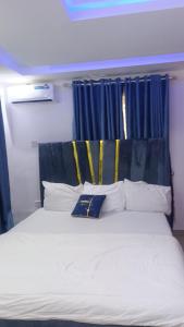 a bed with white sheets and pillows in a room at Luxury and premium one bed in Ikeja